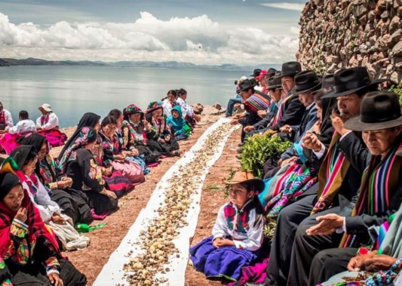 Pobladores andinos realizando una ofrenda a la Pachamama en una ceremonia tradicional de creencias del peru